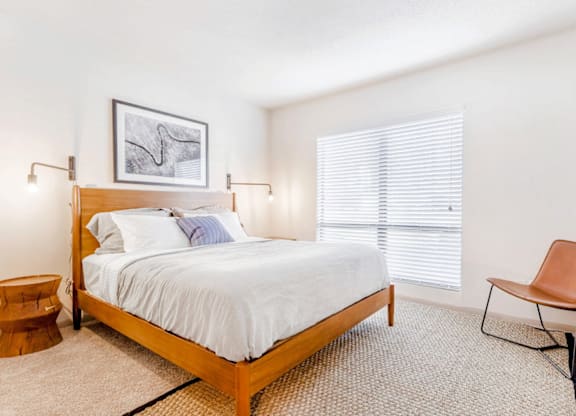 A bedroom with a bed, chair, and picture on the wall at Madison Southpark Apartment Homes, Charlotte, NC