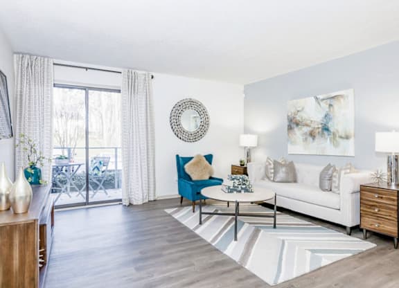 A living room with a blue chair and a white couch at Madison Southpark Apartment Homes, Charlotte