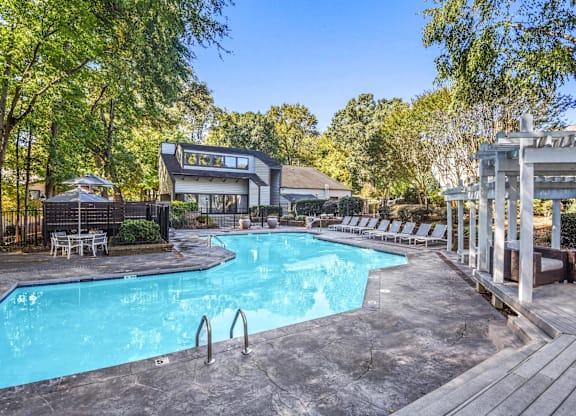 A large outdoor swimming pool surrounded by trees at Madison Southpark Apartment Homes, North Carolina, 28226