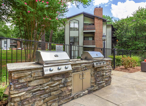 A stone wall with a grill on top of it at Madison Southpark Apartment Homes, Charlotte