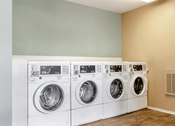 A row of white front load washing machines in a laundry room at Madison Southpark Apartment Homes, Charlotte