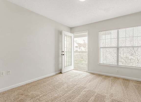 A room with a carpeted floor and a window with blinds. at The Grayson Apartment Homes, Charlotte, 28262