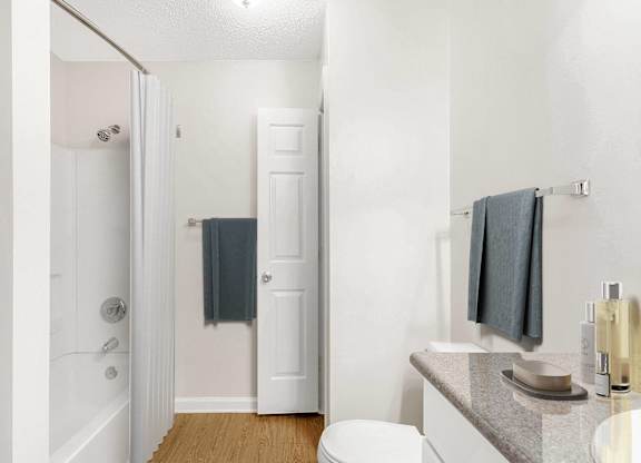 A white bathroom with a toilet, sink, and bathtub. at The Grayson Apartment Homes, Charlotte