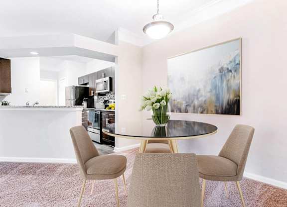 A modern dining room with a glass table and chairs.