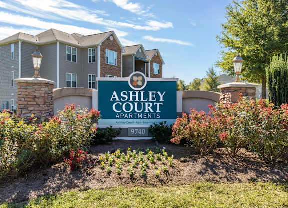 Community Entrance Sign with Decorative Plants and Shrubs  in Front of Trees and Building Exteriors at Ashley Court Apartments, Charlotte, NC, 28262