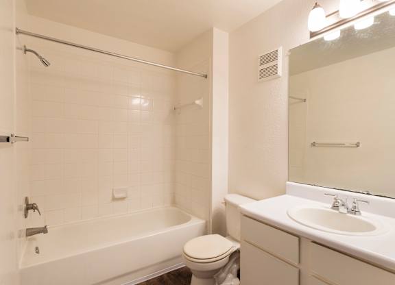 A white bathroom with a toilet, sink, and bathtub.