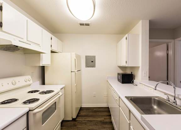 A kitchen with white appliances and cabinets.