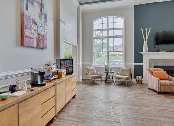 A living room with a fireplace and a painting on the wall.
