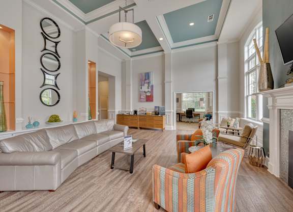 Clubhouse rest area with a white couch and a fireplace.