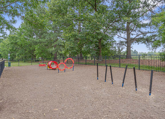 A playground with a red swing set and blue poles.
