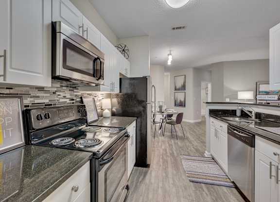 A kitchen with a black stove top oven and a black refrigerator.