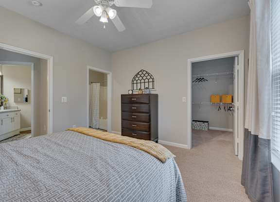 A bedroom with a bed, dresser, and mirror.