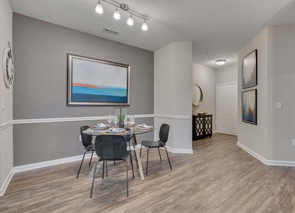 A dining room with a table set for four.