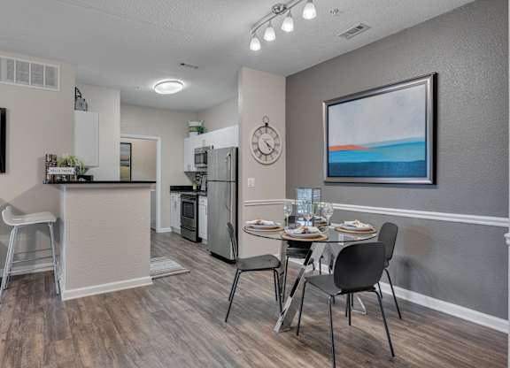 A modern kitchen with a dining table set for two.