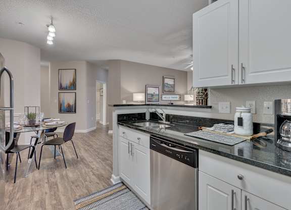 A kitchen with a dining table and chairs.