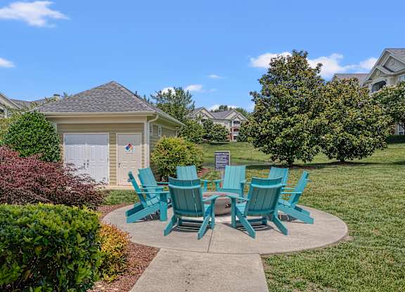 A set of six green chairs are arranged around a table in a circle.
