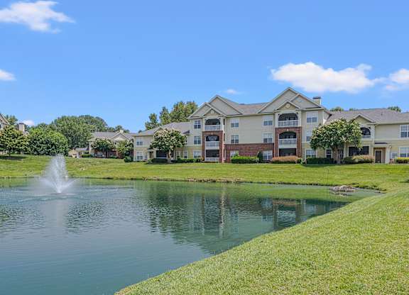 An apartment buildiong with a fountain in front of it.