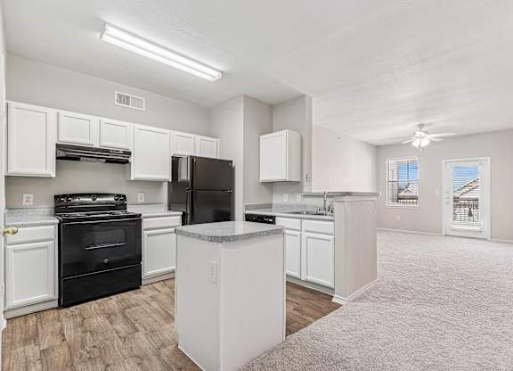 A kitchen with white cabinets and black appliances.