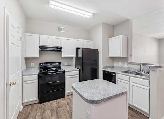 A kitchen with black appliances and white cabinets.