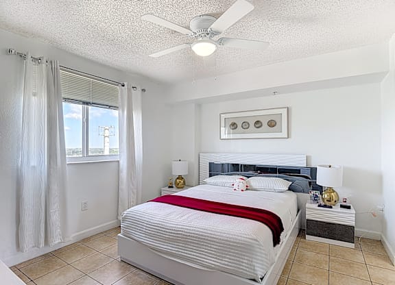 A bedroom with a large bed and a ceiling fan.