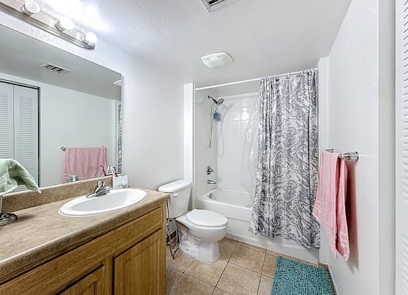 A bathroom with a toilet, sink, and shower.