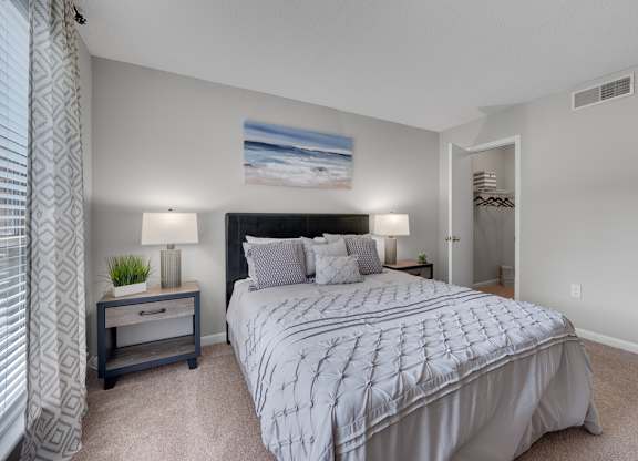 A bedroom with a large bed and a painting on the wall.