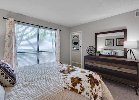 A bedroom with a bed, dresser, and mirror.