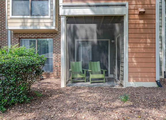 A patio with a chair and a table is visible through a glass door.