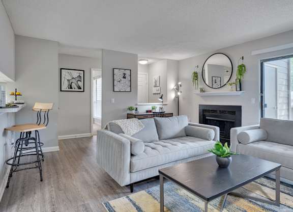 A living room with a grey couch, a black coffee table, and a fireplace.