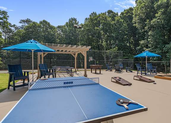 A blue table tennis table is in the middle of a playground.