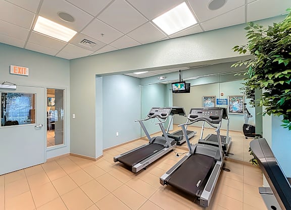 A gym with treadmills and an exit sign.