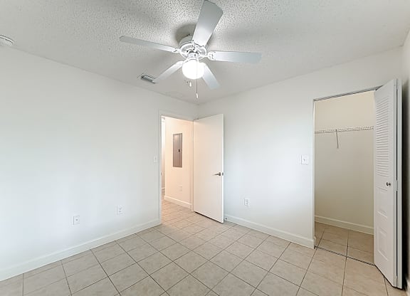 A room with a ceiling fan and tile flooring.