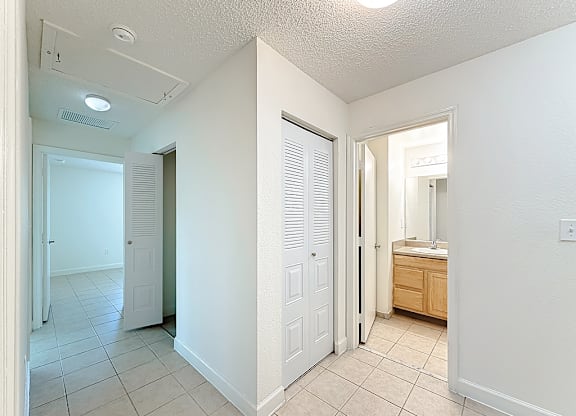 A white bathroom with a sink and a mirror.