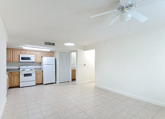 A kitchen with white appliances and wooden cabinets.