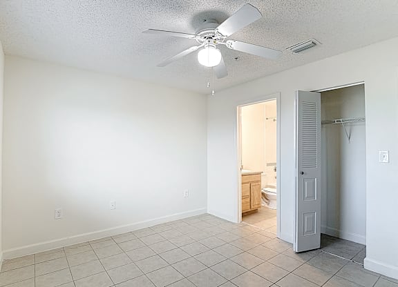 A room with a ceiling fan and tile flooring.