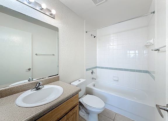 A white bathroom with a sink, toilet, and bathtub.
