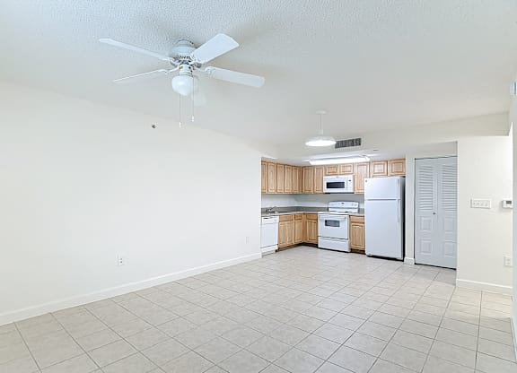 A kitchen with white appliances and wooden cabinets.