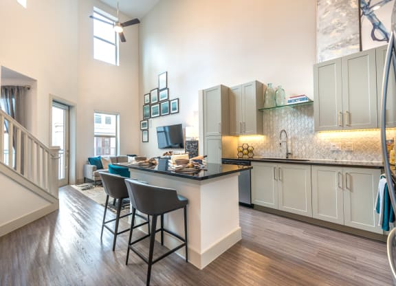 Kitchen area facing exterior patio door and staircase from the living room