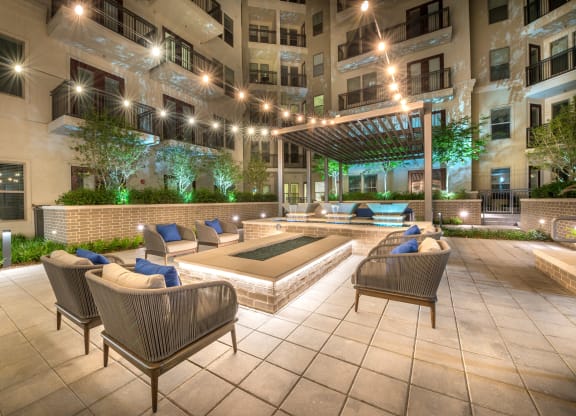 Outside seating area surrounding water fixture and decorative outdoor lighting