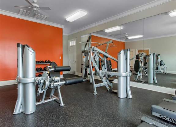 Fitness Center with Exercise Equipment with Orange and Mirror Accent Wall