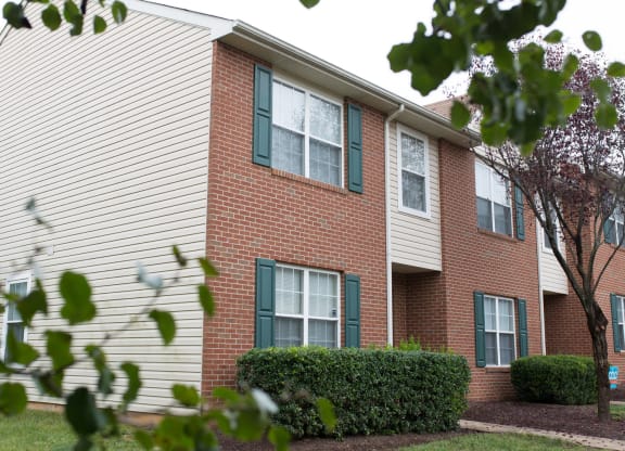 exterior of apartment building with trees and bushes