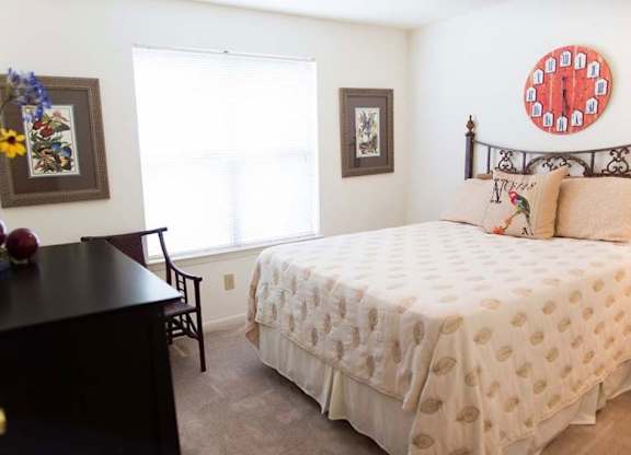 A bedroom with a bed, a chair, and a dresser at Fox Hollow Apartment Homes, North Carolina, 27265