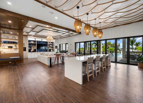 the home has a large entertaining area with a bar and glass doors to the pool