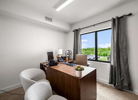 an office with a large window and a desk with a computer