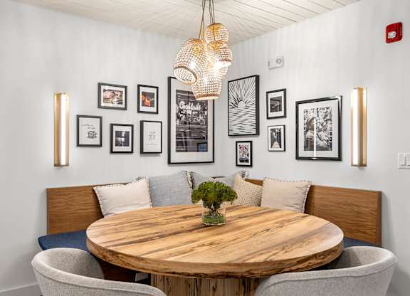 a dining room with a table and chairs and pictures on the wall