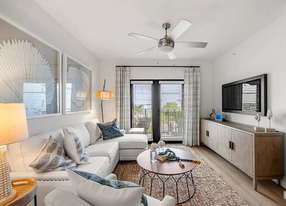 a living room with a white couch and a ceiling fan