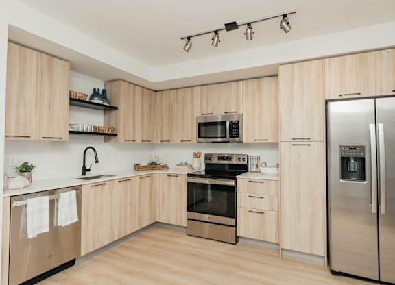 a kitchen with wooden cabinets and stainless steel appliances
