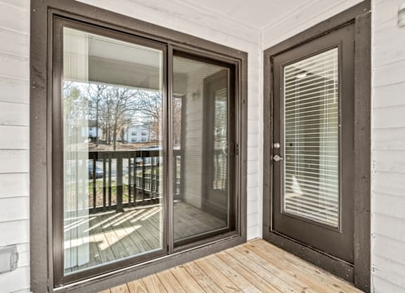 A glass door with a wooden floor and a white wall at Paces Pointe Apartment Homes, Matthews, 28105