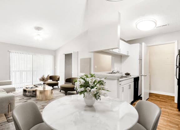 A modern kitchen and living room with a dining table set for two at Paces Pointe Apartment Homes, Matthews