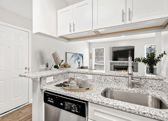 A modern kitchen with a granite countertop and stainless steel appliances at Paces Pointe Apartment Homes, Matthews, 28105